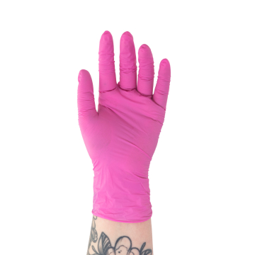 Hand wearing a pink Killer Beauty nitrile glove showing palm side with tattooed wrist background white